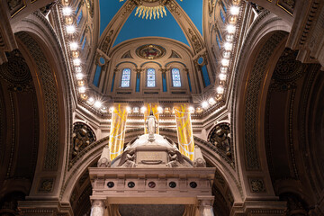 landmark basilica interior under dome above sanctuary built in beaux arts architectural style...