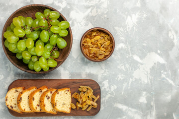 top view fresh green grapes with raisins and cake slices on light-white desk cake biscuit fruit fresh mellow