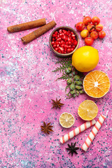 Fototapeta na wymiar top view fresh lemon with cinnamon and pomegranates on pink desk fruit fresh mellow color