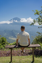 man looking at Agung volcano in Indonesia, Bali island , beautiful landscape of volcano.