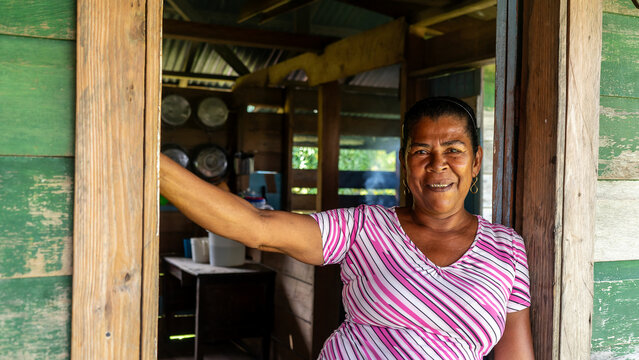 Afro-descendant woman from the Caribbean seeing camera and smiling in the doorway of her wooden house in the Caribbean of Nicaragua