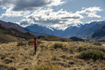 Senior woman standing in the middle of the landscape contemplating the nature around her..