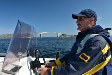 Mann fährt Motorboot an der Atlantikstraße 
