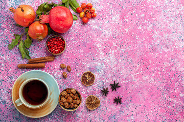 top view fresh pomegranate with green leaves and cup of tea on the pink background fruit fresh mellow autumn tree plant color