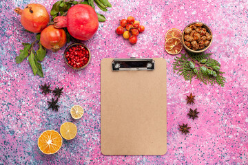 top view fresh pomegranate with notepad on pink background fruit fresh mellow autumn tree plant color