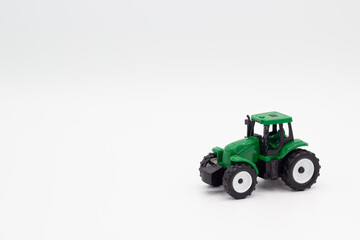 Tractor de juguete verde sobre fondo blanco