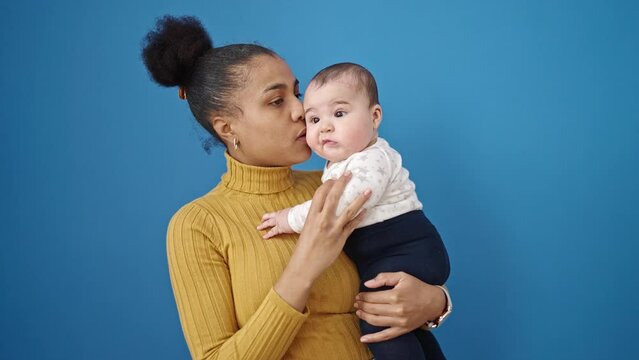 Mother and son smiling confident standing over isolated blue background