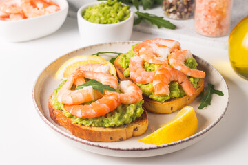 Shrimps on toast with avocado and lemon. Breakfast concept. Bruschetta. 