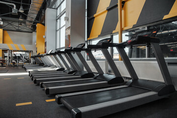 Modern fitness center interior with sports equipment - sport treadmills machine. New gym inventory...