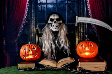 Halloween grim reaper reading book with two jack o lanterns