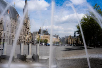 Fototapeten Fountains in the market square of Ypres on a beautiful sunny day. Tourist image for promotion of Ypres Belgium or Ieper België.  Capital of the westhoek belgium.  Lakenhalle, Belfort, Niewerck. © robin