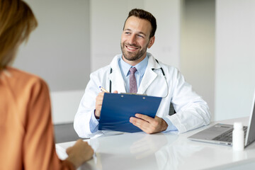 Female patient sharing talking with doctor man during meeting in office, male physician holding clipboard and making notes, free space