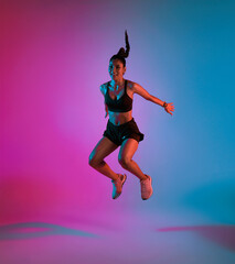 Fototapeta na wymiar Young Asian sporty woman in sports outfits doing stretching before workout in fitness studio neon background. Healthy young woman warming up.