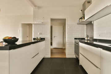 a kitchen with white cabinets and black counter tops in the center of the image is an open door...