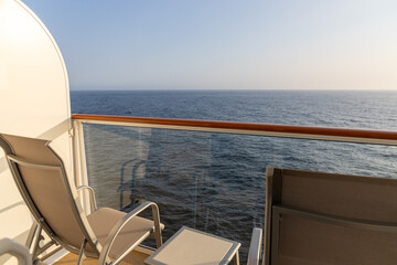 Cruise ship balcony with a chair and a table.