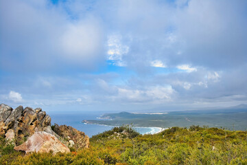 Fototapeta na wymiar Panoramic view from the top of Mount Barren over the coast of Fitzgerald River National Park, south coast of Western Australia. White clouds, sweeping bay and a long road 