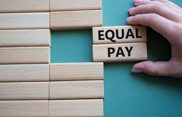 Equal Pay symbol. Wooden blocks with words Equal Pay. Beautiful grey green background. Businessman...