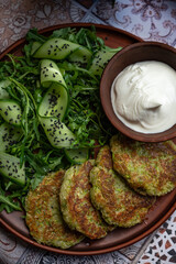 Zucchini pancakes with arugula and cucumbers