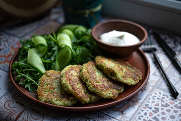 Zucchini pancakes with arugula and cucumbers