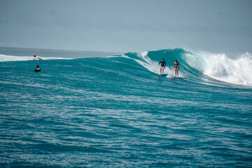 Two Surfer girls on long boards on perfect blue aquamarine wave together, party wave, empty line...