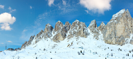 Morning winter Gardena Pass panorama with ski station (Italy). All people are unrecognizable.