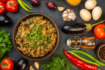 Above view of eggplant meal fallen oil bottle fresh vegetables green bundle pepper on dark color background