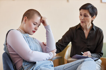 Mature psychologist supporting teenage girl during their conversation at psycho session