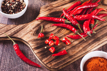 Crushed red hot peppers and whole peppers on a wooden board