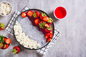 Breakfast plate of cottage cheese, chia pudding, jam and strawberries on the table top view