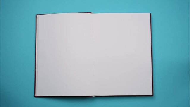 Book opening on a blank page. Top view of businessman workplace, open notebook. Stop motion animation