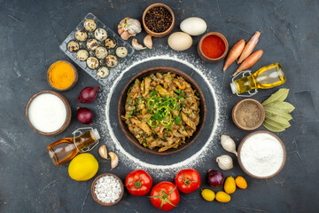 Above view of delicious meal among fallen oil bottle eggs fresh vegetables flour spices on black background