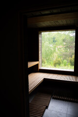 Small home wooden sauna, spa room. Relax in a hot sauna. Inside of empty Finnish sauna room. Modern interior of wooden spa cabin with dry steam.