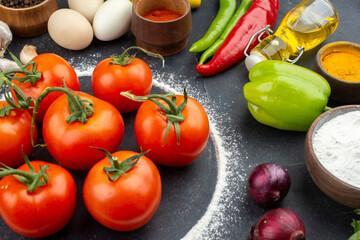 Close up view of dinner preparation with fresh vegetables eggs flour spices on black background