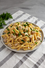 Homemade One-Pot Chicken Alfredo Pasta with Parsley on a Plate, side view.
