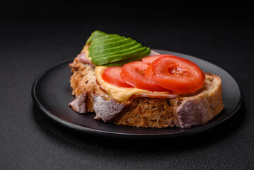 Delicious nutritious grilled toast with ham, cheese, tomatoes and avocado