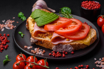 Delicious nutritious grilled toast with ham, cheese, tomatoes and avocado