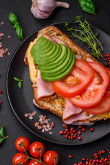 Delicious nutritious grilled toast with ham, cheese, tomatoes and avocado