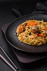 Delicious fresh pilaf with rice, carrots, meat, onions, spices and berries