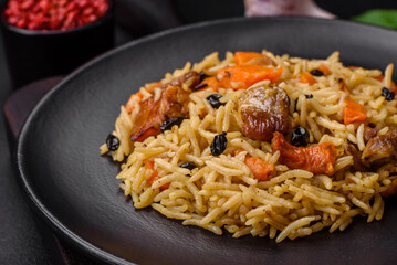 Delicious fresh pilaf with rice, carrots, meat, onions, spices and berries