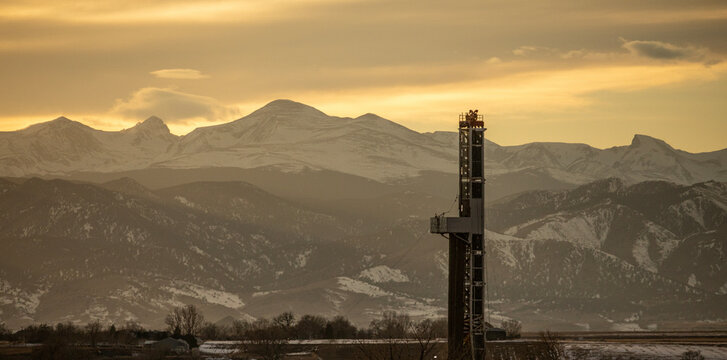 Oil Rig with Mountains During Sunset