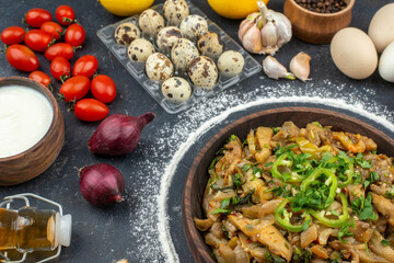 Horizontal view of eggplant dish served with green eggs flour spices vegetables fallen oil bottle on black background