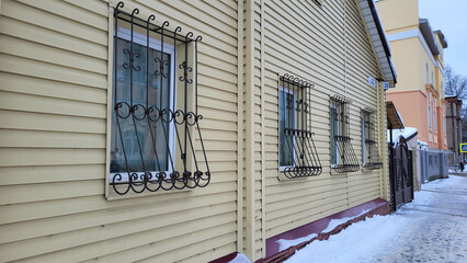 Facade with windows and openwork grilles on a winter day.