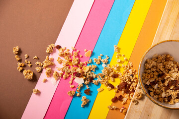 Scattered granola in bowl and on table with multicolored lines
