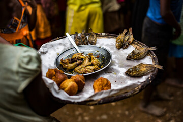 Delicious roasted chicken with fried fish and bean cake on tray with people