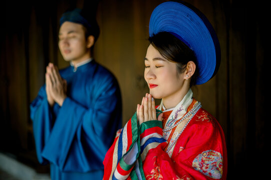 Stylish Asian couple in traditional clothes praying