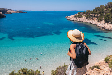 Anonymous young woman admiring amazing view of blue sea on Balearic Islands