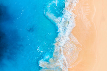 Fototapeta na wymiar Coast as a background from top view. Waves and beach. Aerial landscape. Azure water background from drone. Summer seascape from air. Vacation time.