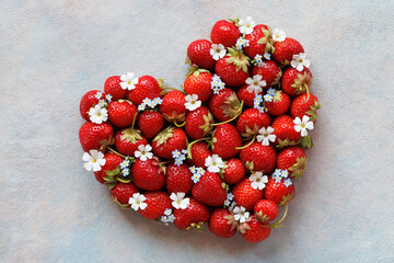 Heart from strawberries with flowers on a decorative background, beautiful postcard, valentine