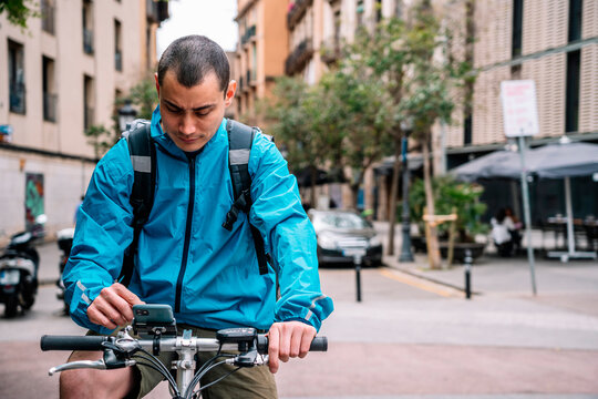 Man in service jacket using phone while riding bicycle