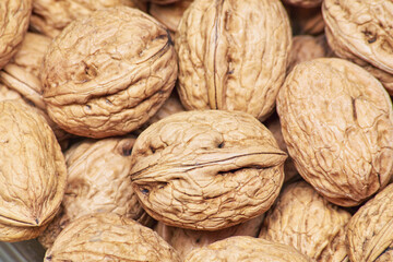 Stacked unpeeled solid walnuts pattern texture background
